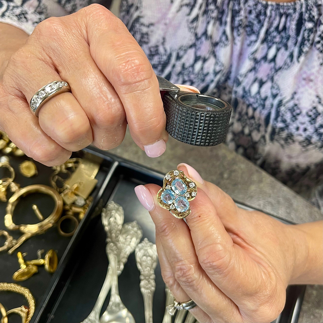 A woman examining a piece of silver jewelry