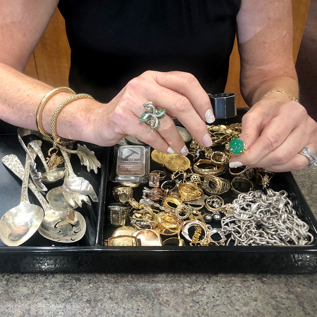A woman examining several pieces of jewelry