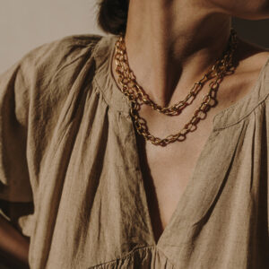 Lavishly layered gold necklaces on woman